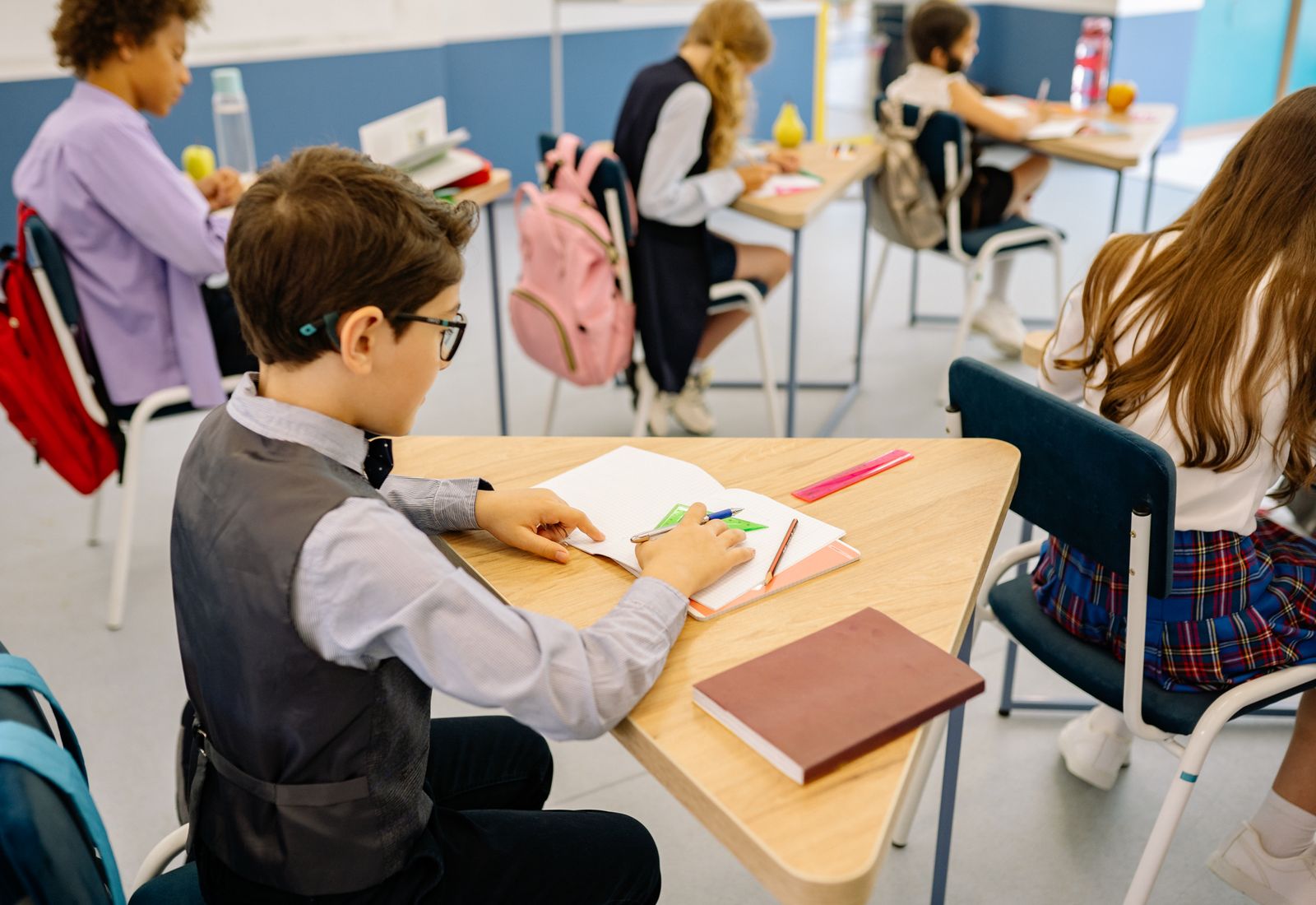 Žák soustředěně píše do sešitu při výuce matematiky